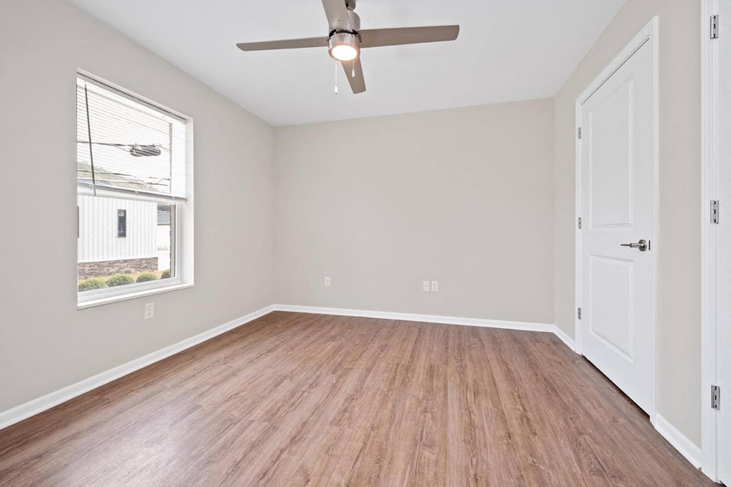 a bedroom with hardwood floors and a ceiling fan