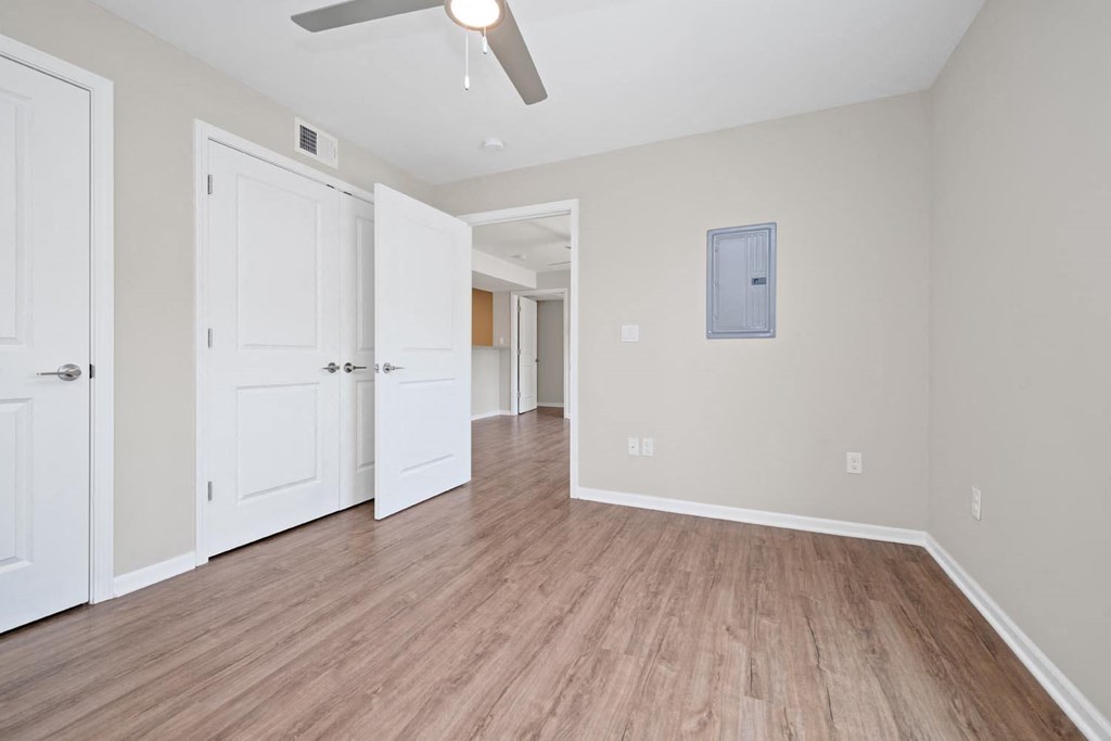 a bedroom with hardwood floors and a ceiling fan