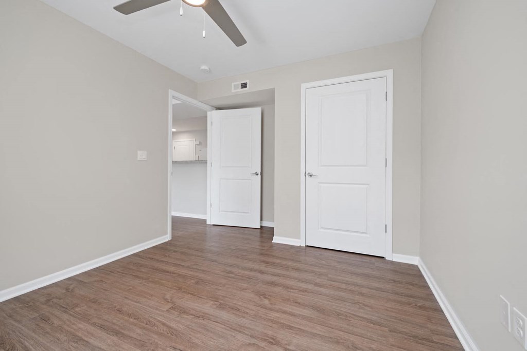 a bedroom with a ceiling fan and hardwood floors