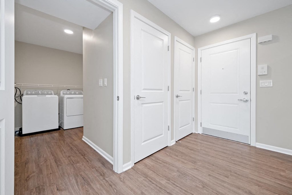 a bedroom with two closets and a washer and dryer