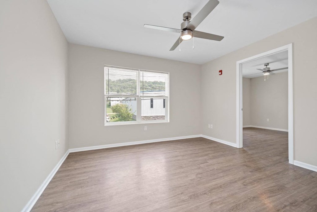 a bedroom with hardwood floors and a ceiling fan