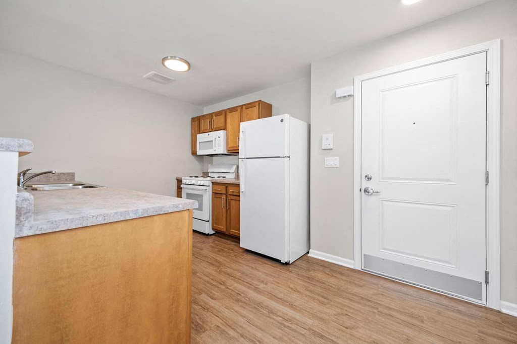 a kitchen with a white refrigerator freezer next to a stove top oven