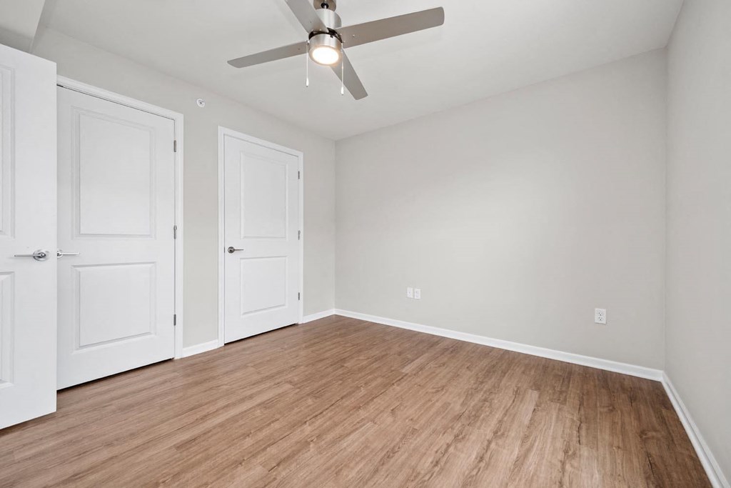 a bedroom with a ceiling fan and hardwood floors