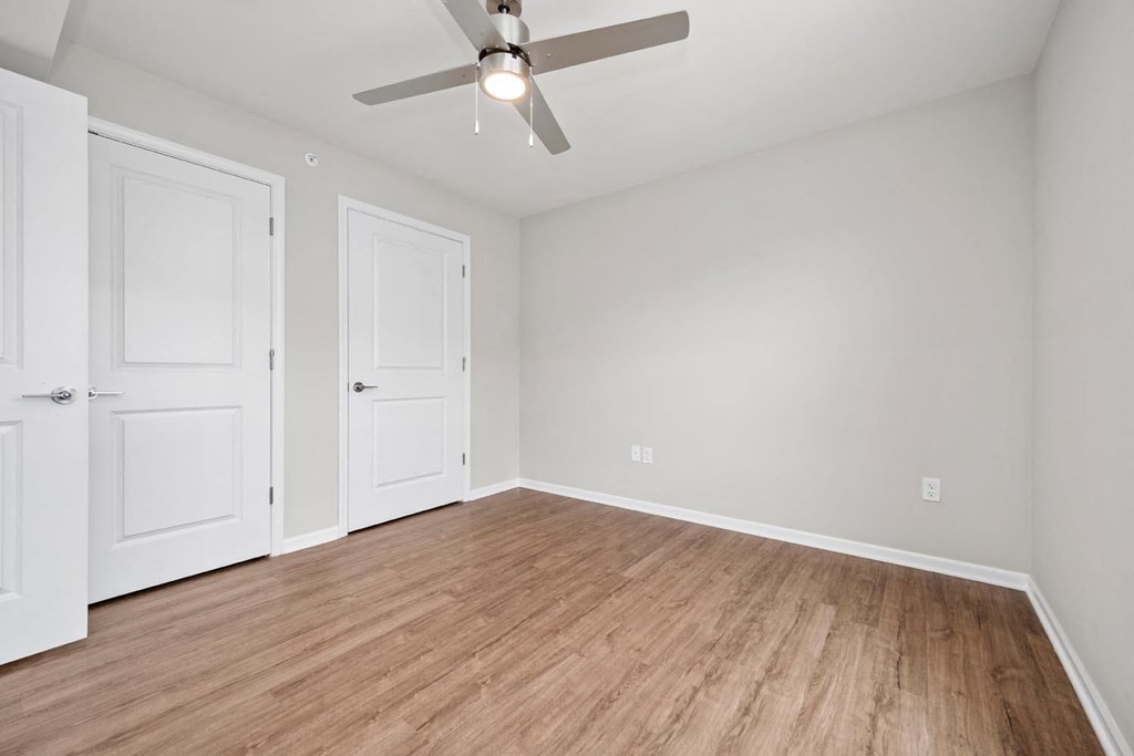 a bedroom with a ceiling fan and hardwood floors