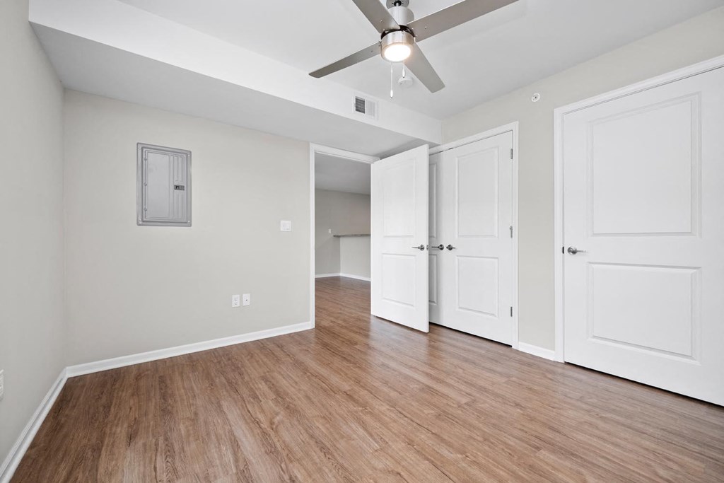 a bedroom with two doors and a ceiling fan
