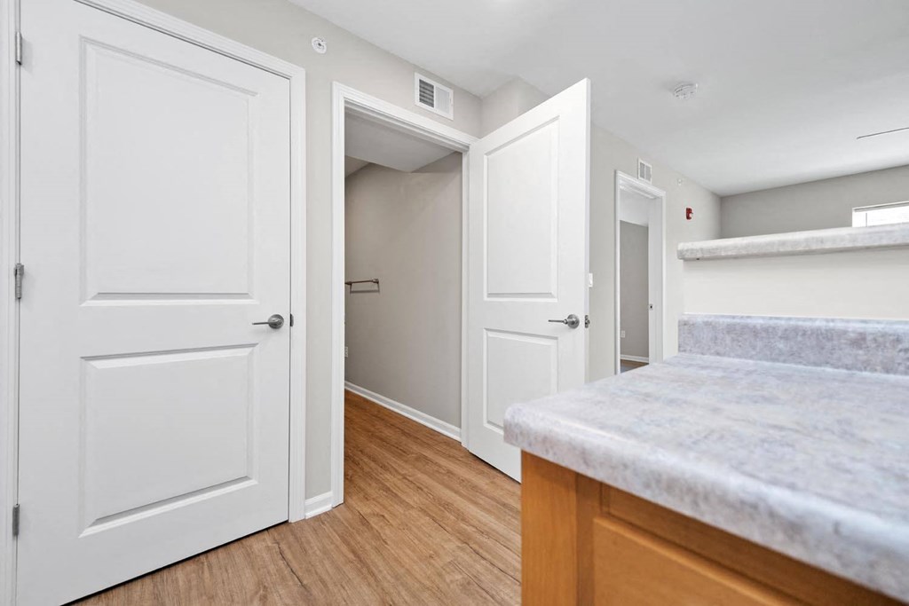 a kitchen with white doors and hardwood floors