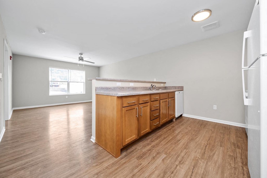 a kitchen and living room with hardwood floors and a large window