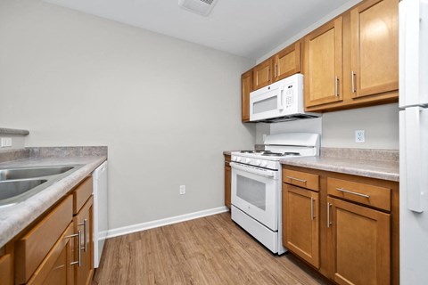 a kitchen with wooden cabinets and white appliances