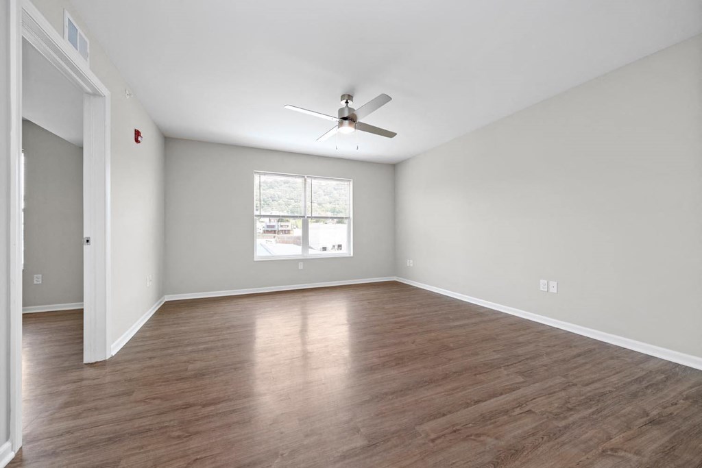 a bedroom with hardwood floors and a ceiling fan