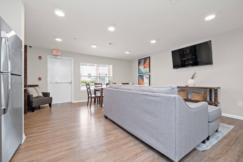 a living room with a couch and a chair in front of a tv