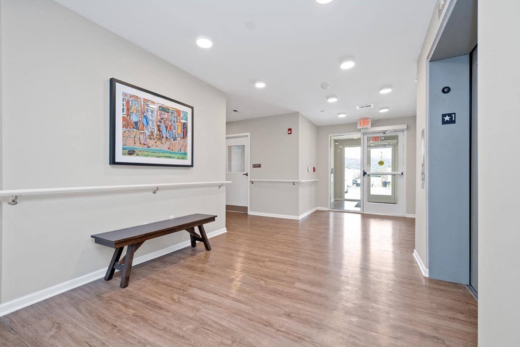 a common area with a bench and a painting on the wall