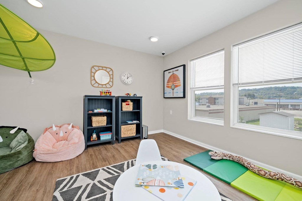 a room with a table and chairs and a large window
