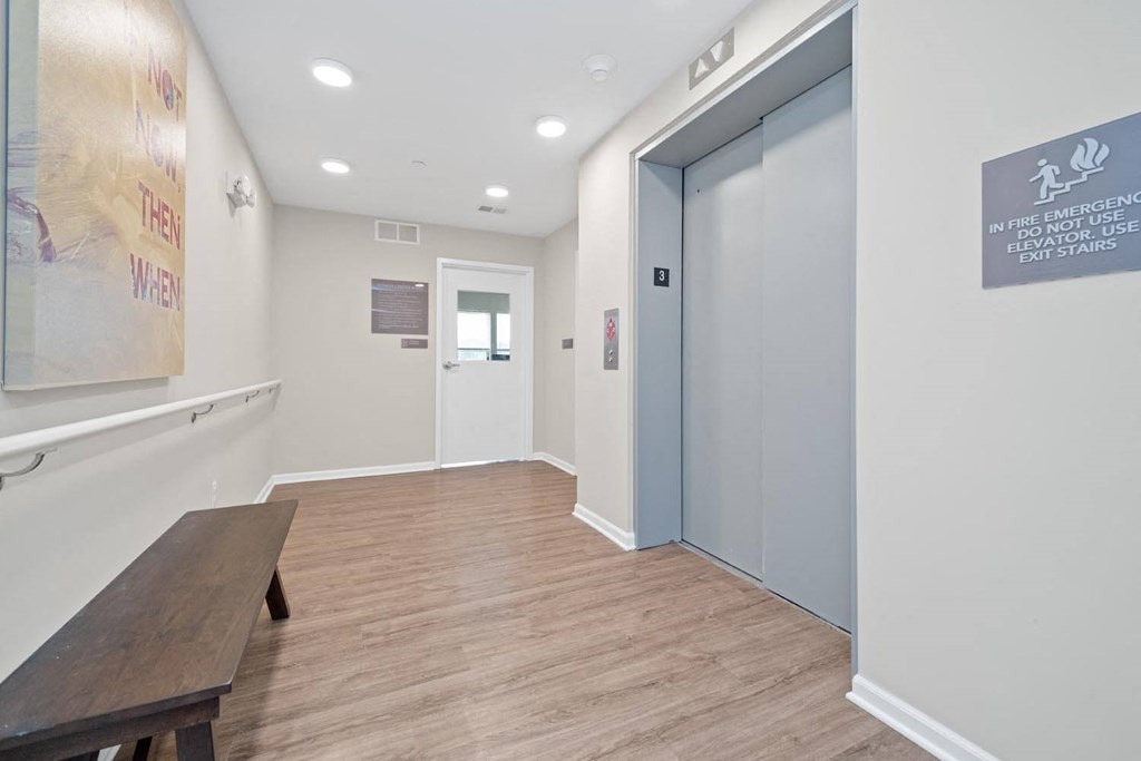 a long hallway with a bench and a door