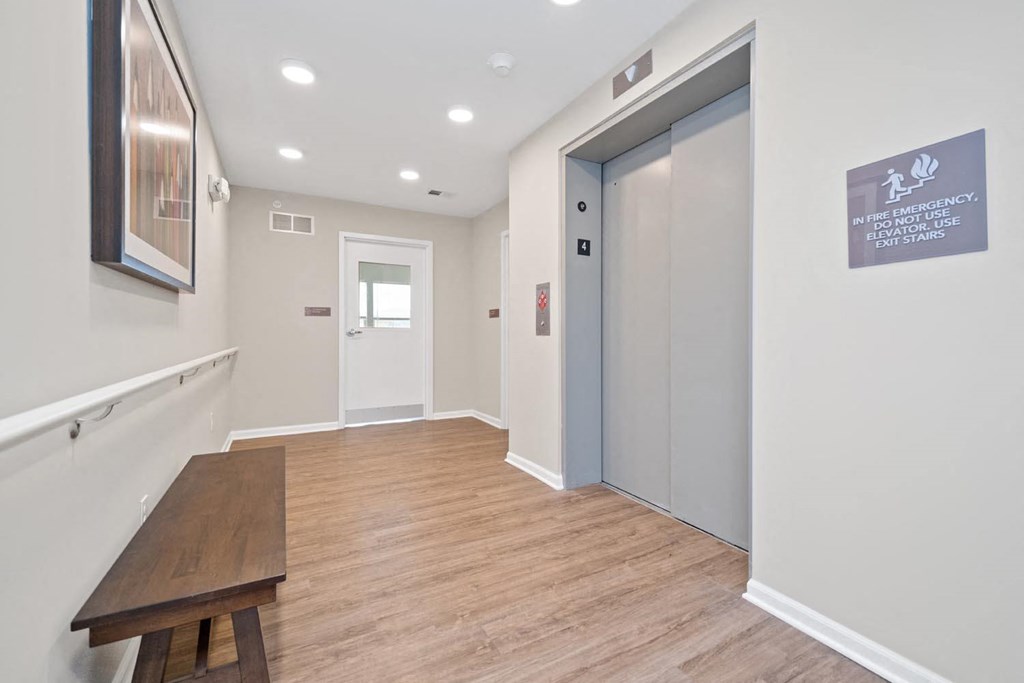 a long hallway with a bench and a door