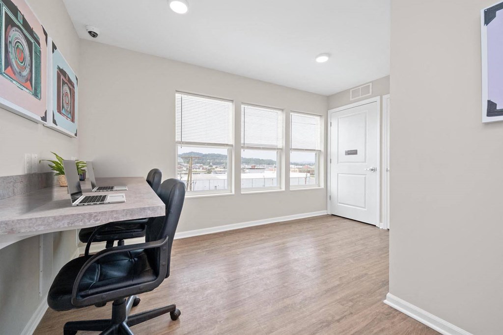 a home office with hardwood floors and a large window