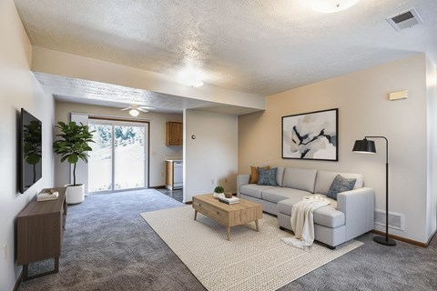 A living room with a grey couch and a wooden coffee table.