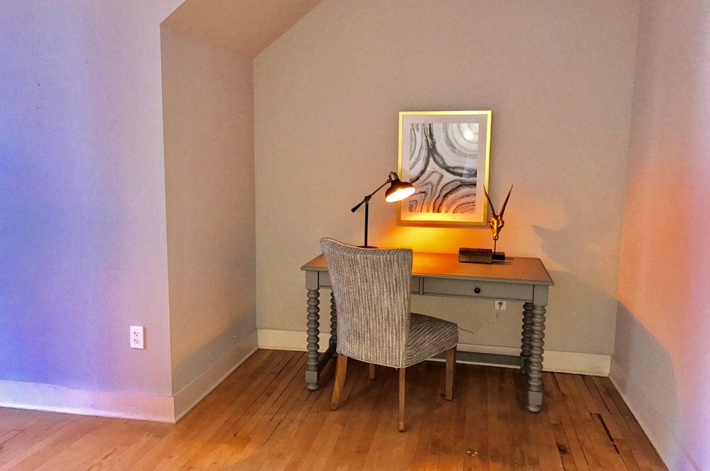 a bedroom with a desk with a chair and a lamp