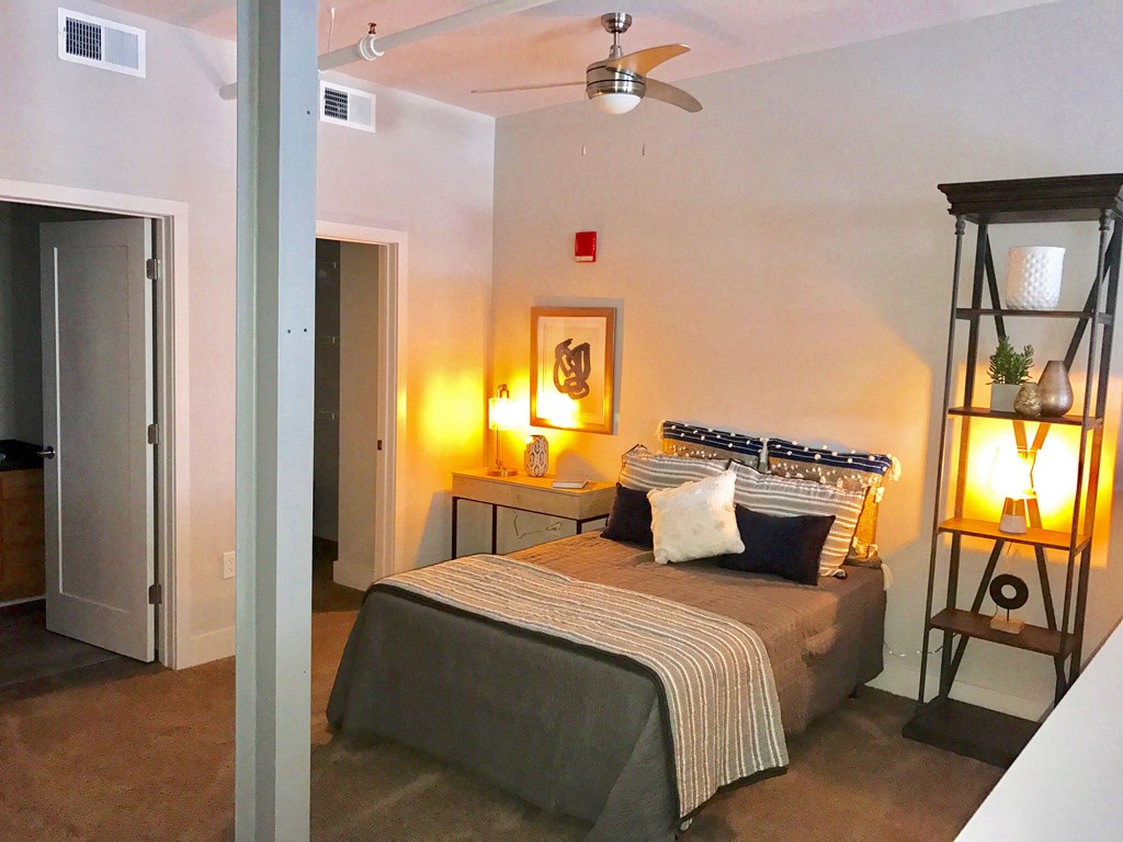 a bedroom with a bed and a ceiling fan