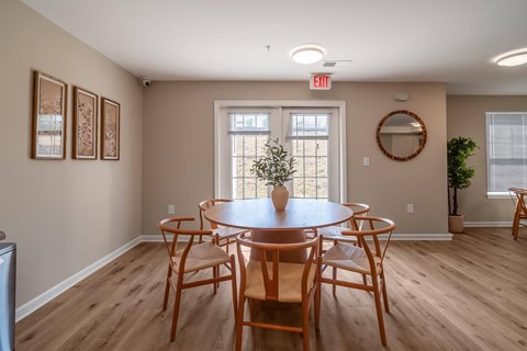 A dining room with a round table and chairs.