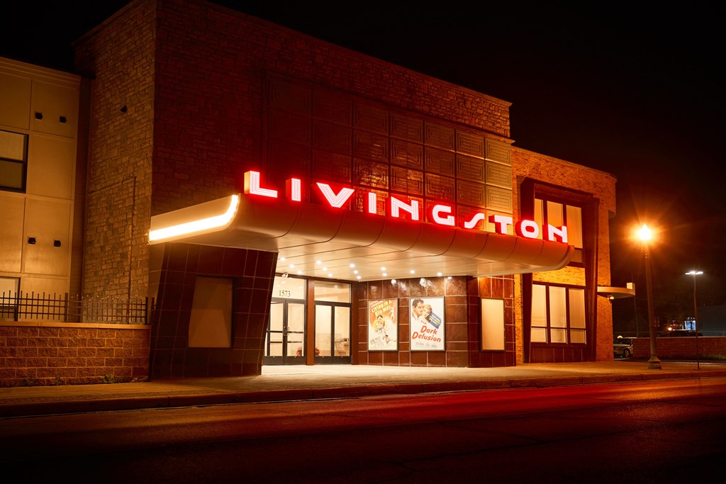 the facade of a building with a neon sign at night
