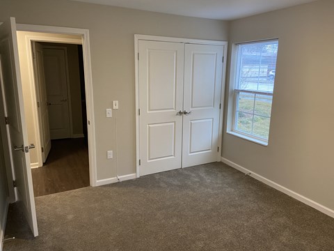 an empty room with two doors and a window