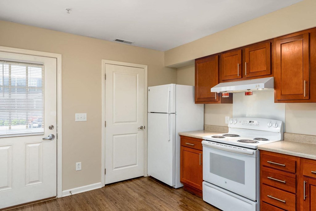 a kitchen with white appliances and brown cabinets