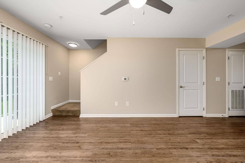 a bedroom with a large window and a ceiling fan