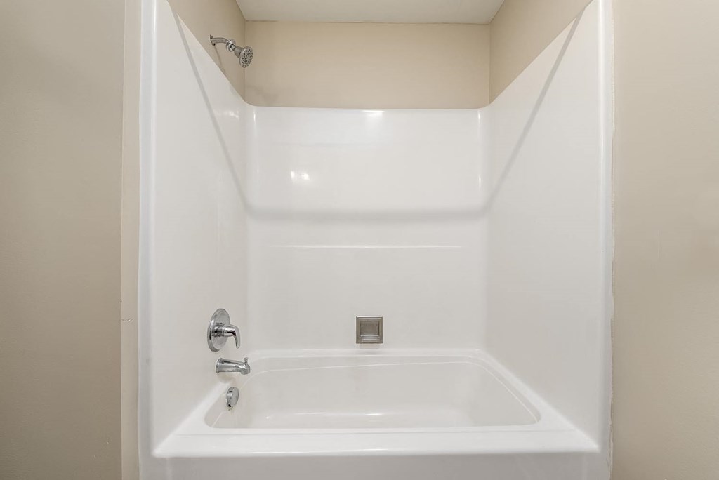 a white bathtub with a silver faucet