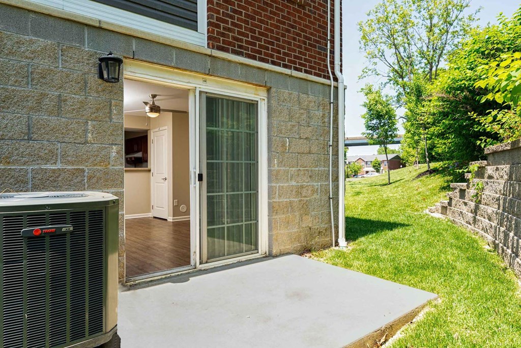 a patio with an air conditioning unit on the side of a building