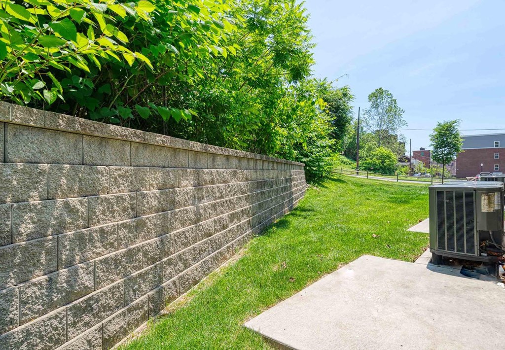 a retaining wall with a garbage can in front of it