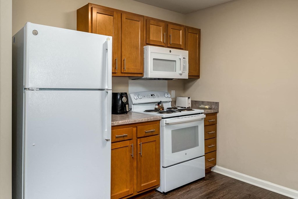 a small kitchen with white appliances and wooden cabinets
