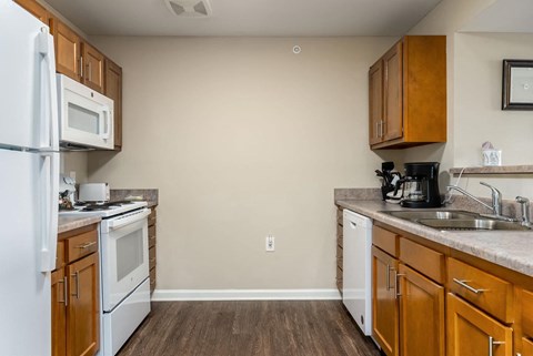 a kitchen with white appliances and wooden cabinets