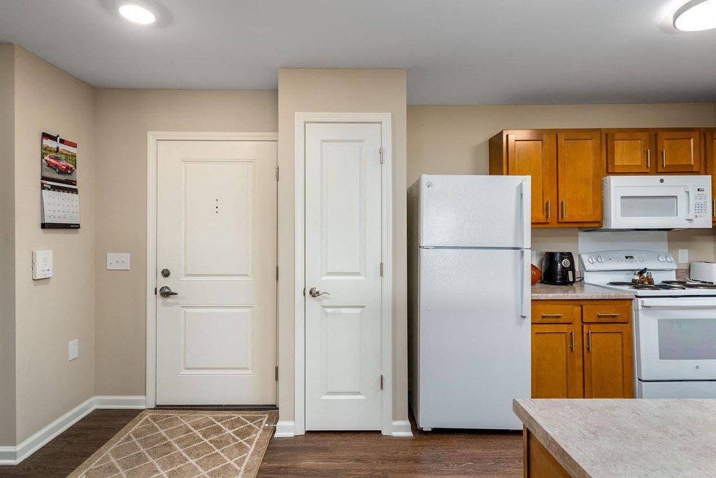 a kitchen with a white refrigerator freezer next to a stove top oven