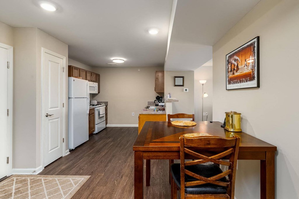 a kitchen and dining room with a wooden table and chairs