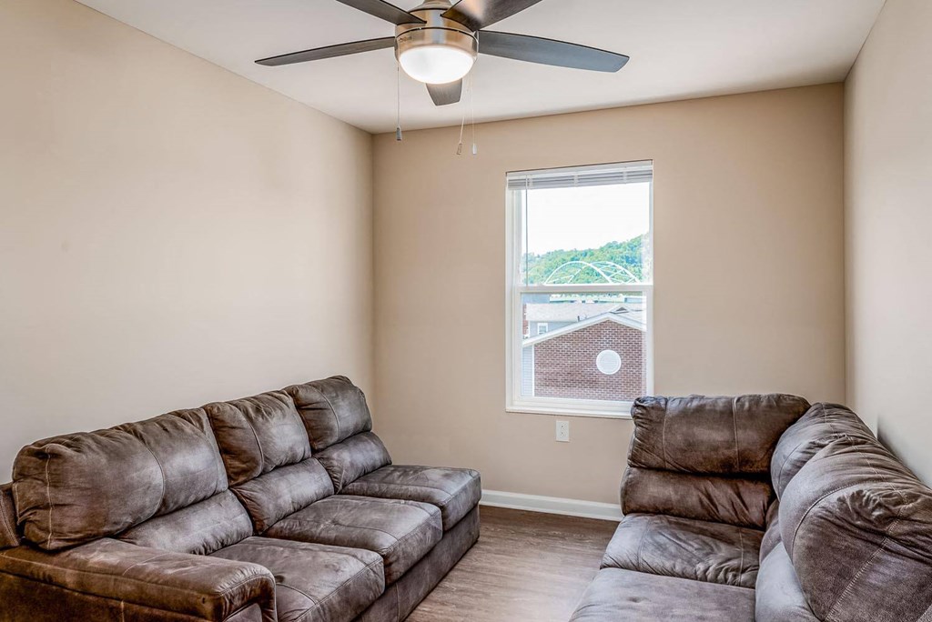 a living room with two couches and a ceiling fan