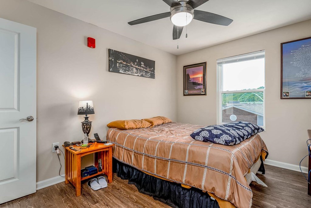 a bedroom with a bed and a ceiling fan
