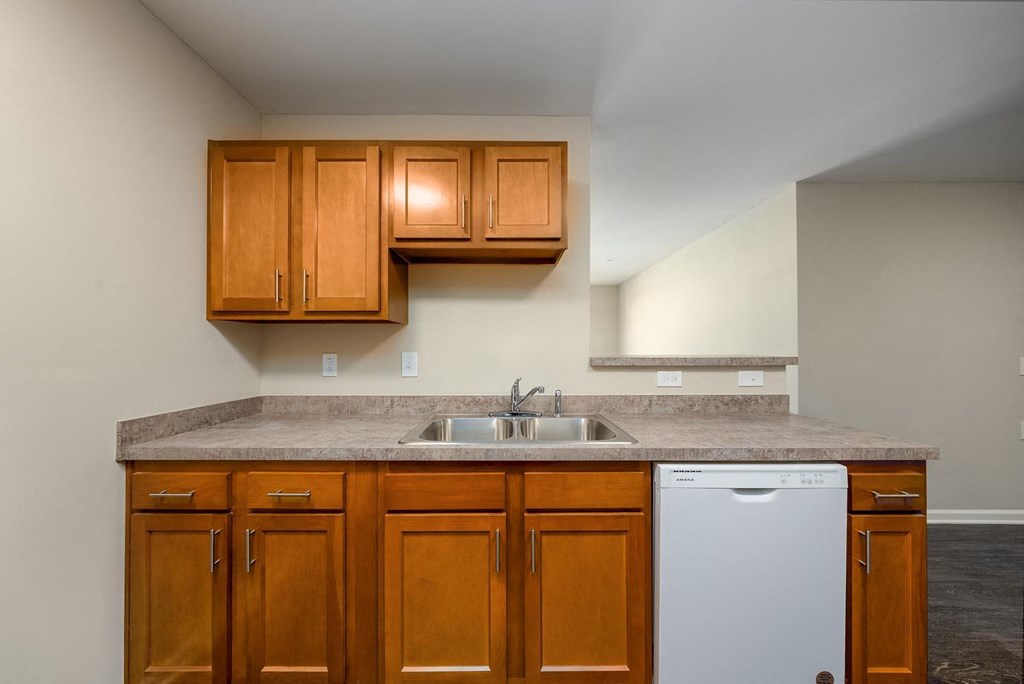 a kitchen with brown cabinets and a white dishwasher