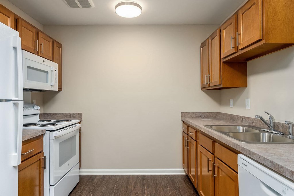 a kitchen with wood cabinets and white appliances