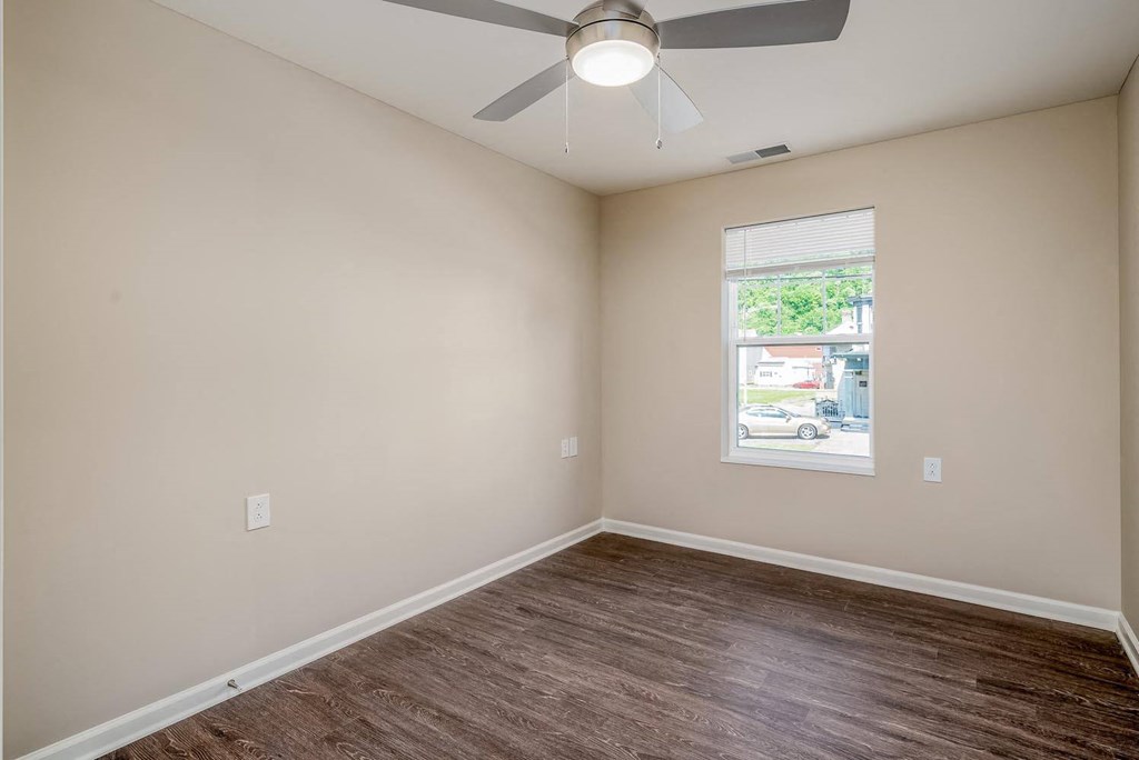 a bedroom with a ceiling fan and a window