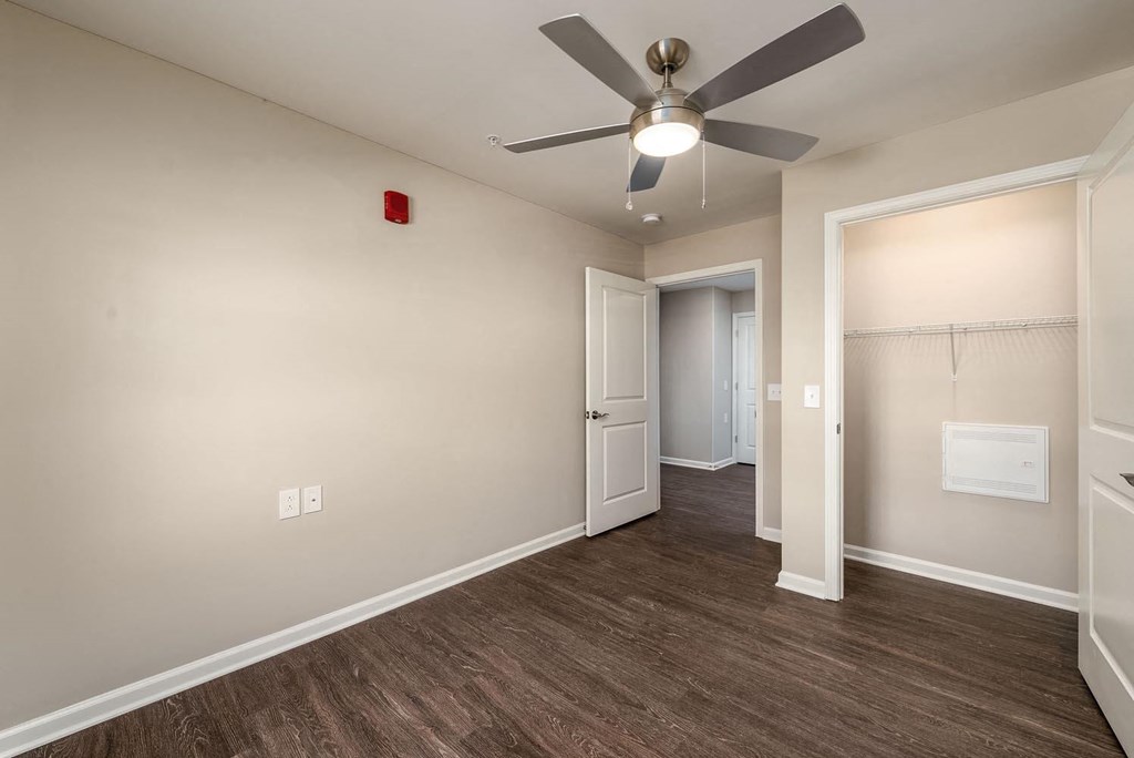 a bedroom with a ceiling fan and a closet