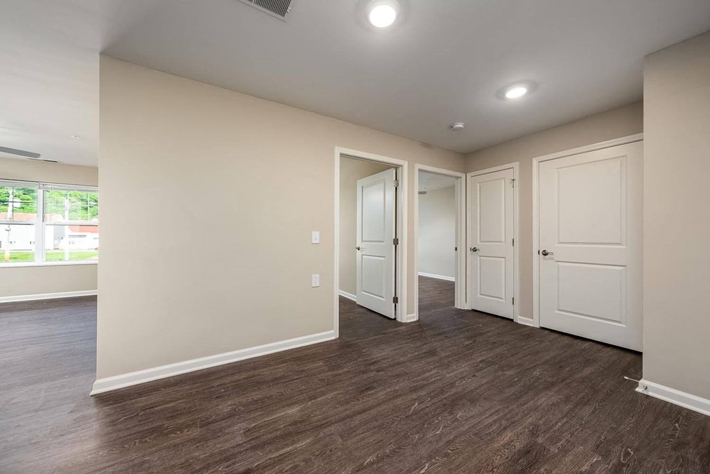 a bedroom with white walls and wood flooring