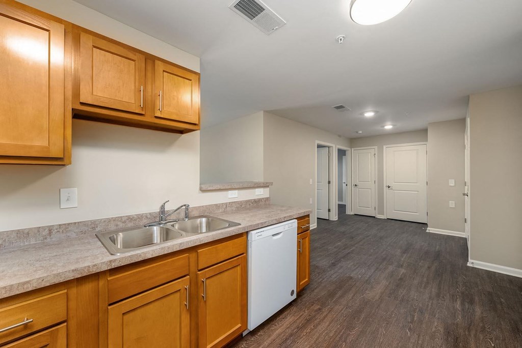 a kitchen with wood cabinets and a white dishwasher