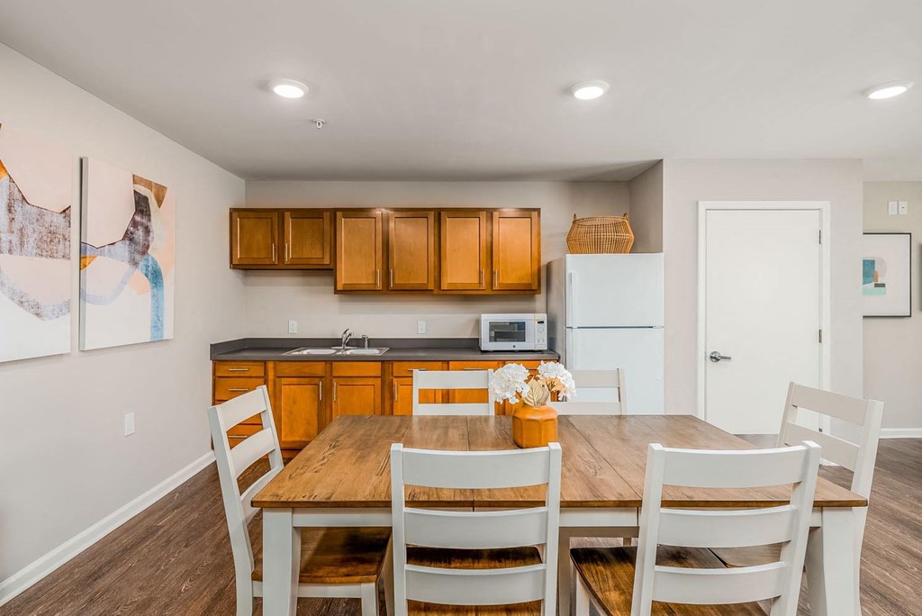 a kitchen with a wooden table and white chairs