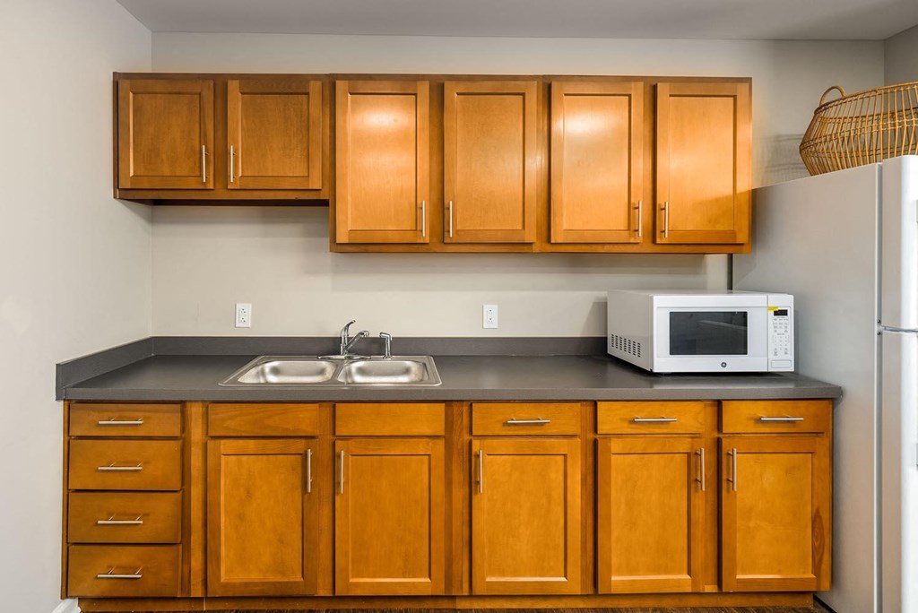 a kitchen with a sink a microwave and a refrigerator