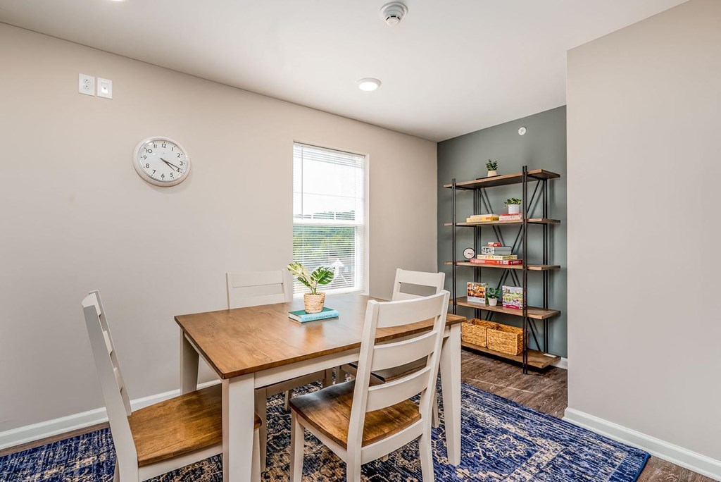 a dining room with a table and chairs and a bookshelf