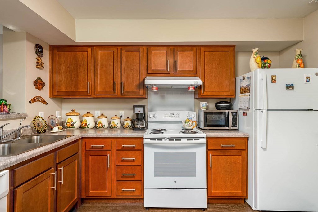 a kitchen with wooden cabinets and white appliances