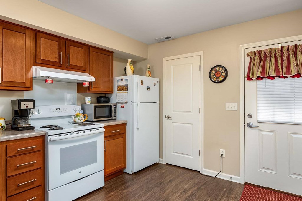 a kitchen with white appliances and wooden cabinets