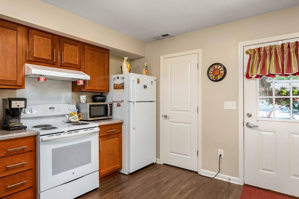 a kitchen with white appliances and wooden cabinets