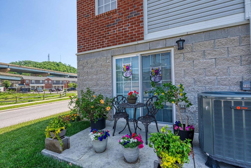 a patio with a table and chairs and potted plants