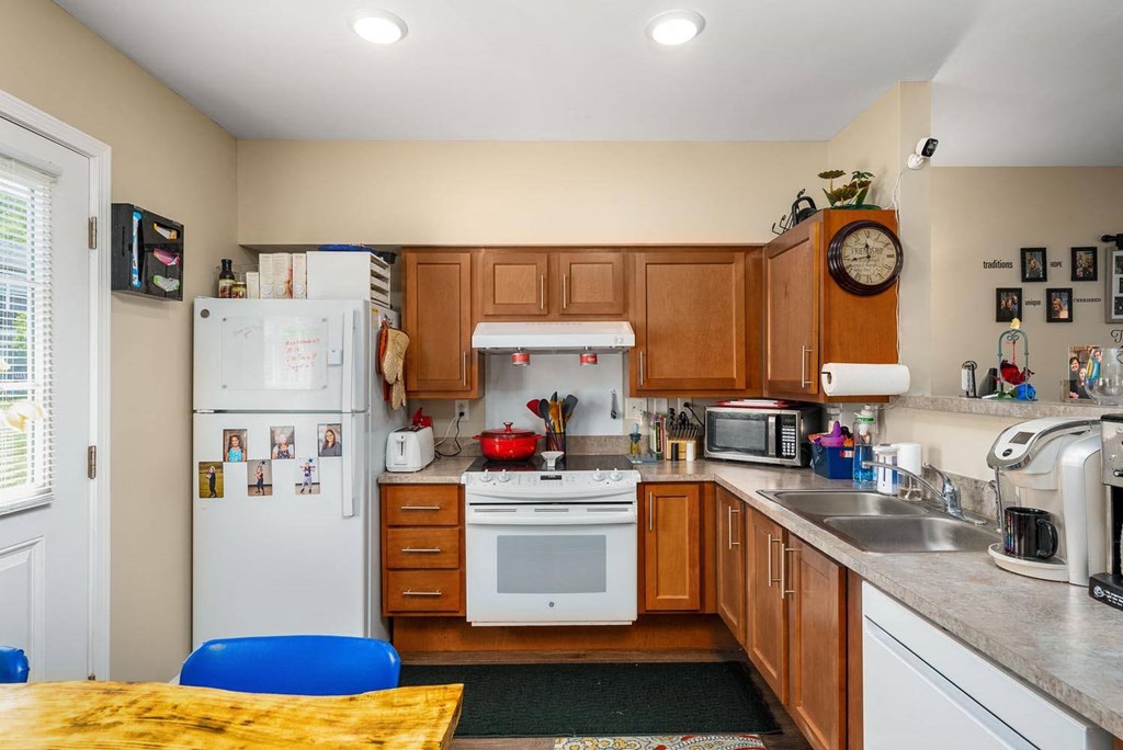 a kitchen with a white refrigerator freezer next to a stove top oven